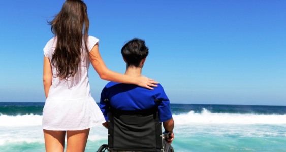 woman and husband in wheelchair on the beach
